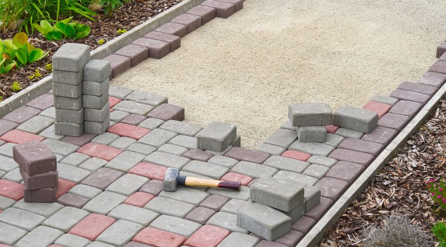 Montaj de pavaje decorative în mai multe culori și modele pentru amenajarea unei alei